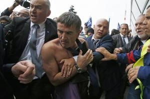 © Reuters. Xavier Broseta, Executive Vice President for Human Resources and Labour Relations at Air France, is evacuated by security after employees interrupted a meeting at the Air France headquarters building in Roissy