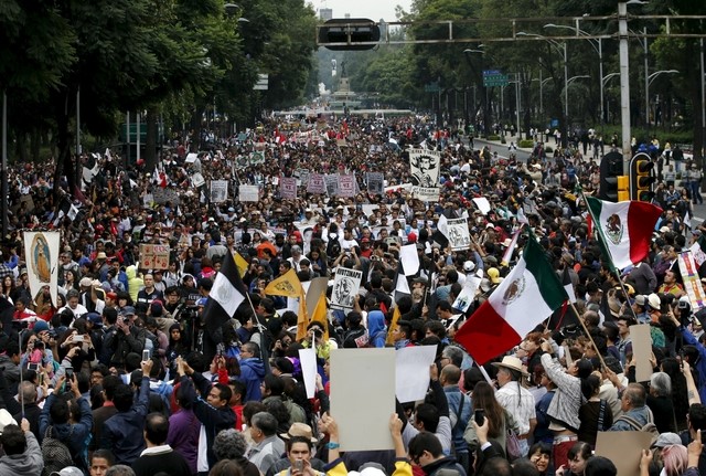 © Reuters. Demonstrators take part in a march to mark the first anniversary of the disappearance of the 43 students from Mexico's Ayotzinapa College Raul Isidro Burgos, in Mexico City