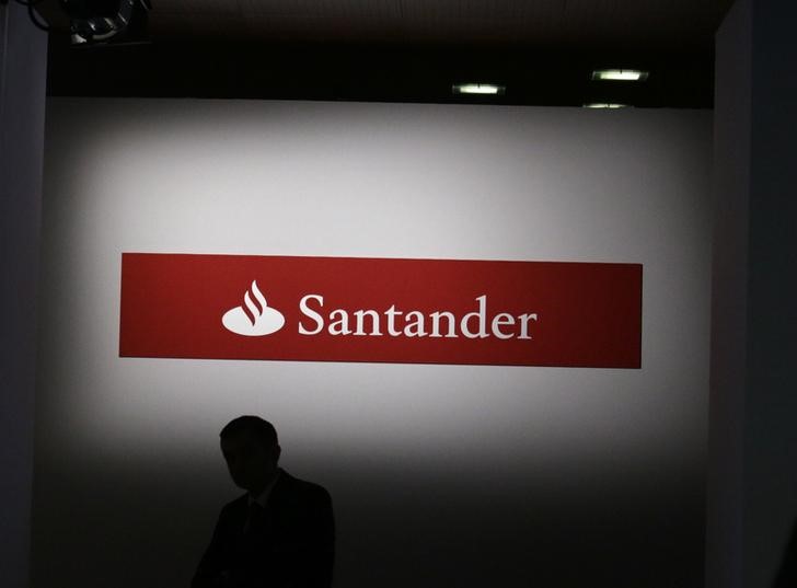 © Reuters. A man walks past a logo of Santander bank during the bank's 2014 results presentation at the company headquarters in Boadilla del Monte, outside Madrid