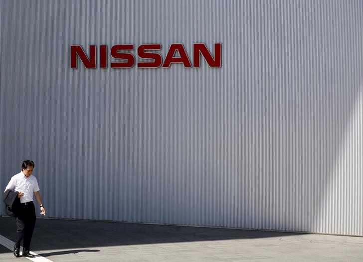 © Reuters. A man walks past the logo of Nissan Motor Co. at the company's showroom in Yokohama