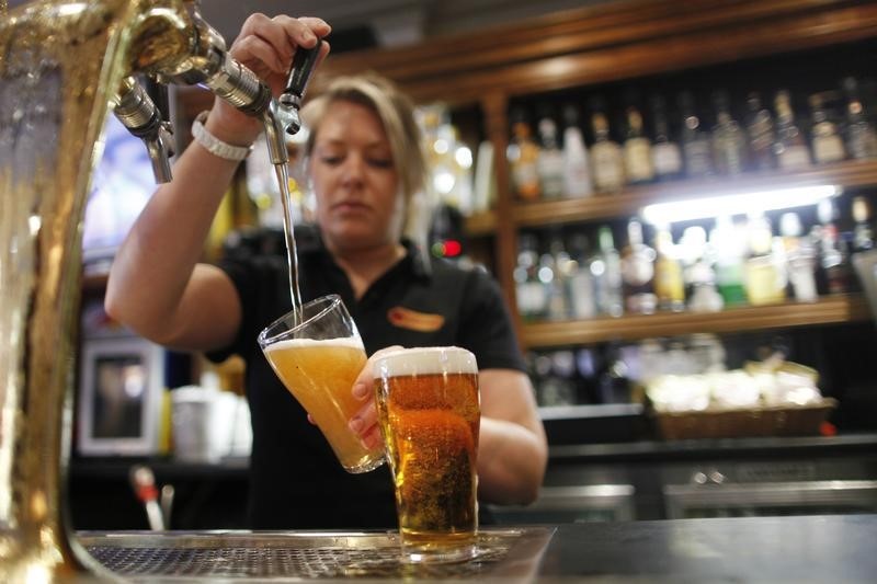 © Reuters. Funcionária enchendo copos de cerveja em Sydney