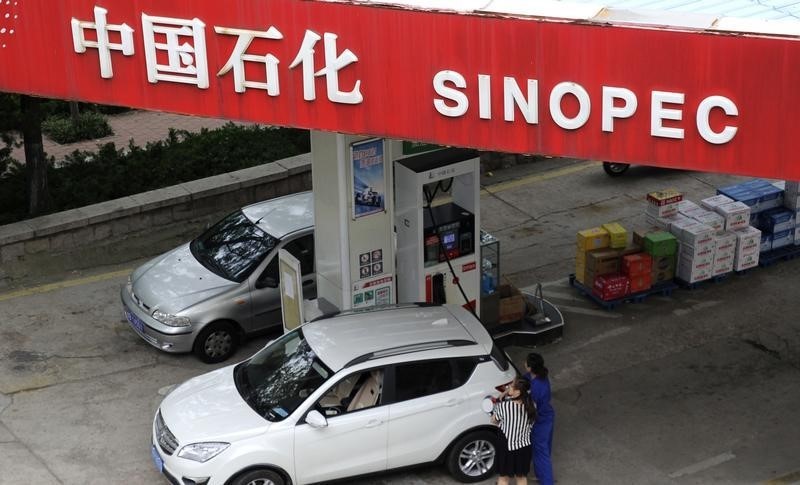 © Reuters. A customer gets the tank of her car filled at a Sinopec gas station in Qingdao