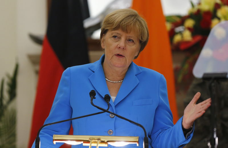 © Reuters. German Chancellor Merkel gestures as she reads a joint statement next to Indias Prime Minister Modi after their delegation-level talks at Hyderabad House in New Delhi