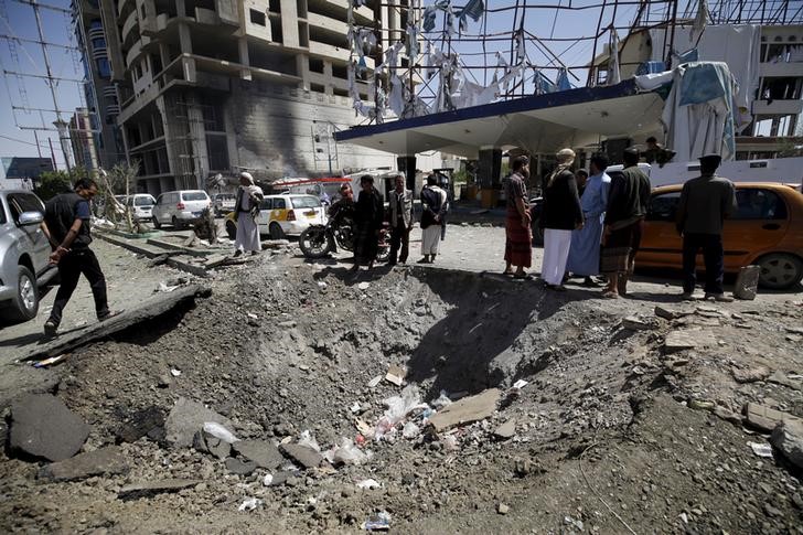 © Reuters. Moradores em meio a destroços em Sanaa, no Iêmen