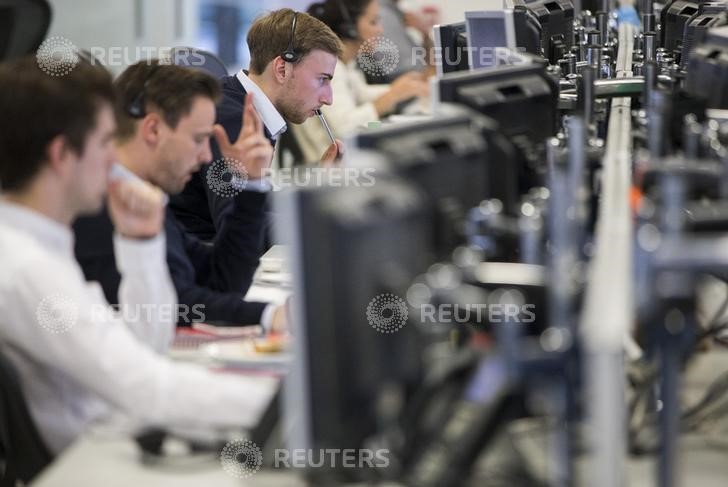 © Reuters. Dealers work on the IG Group trading floor in London, Britain