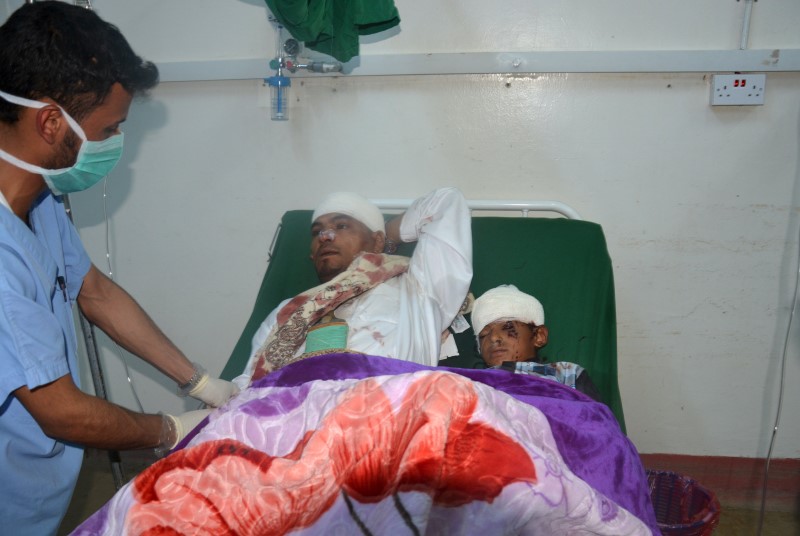 © Reuters. A man and a boy who were injured in a rocket attack on a village in southwest Yemen, rest on a hospital bed at Dhamar hospatil in Dhamar province