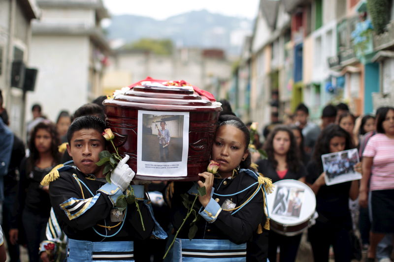 © Reuters. Bandmates participate in the funeral of Bryan Sandoval, a mudslide victim in Santa Catarina Pinula