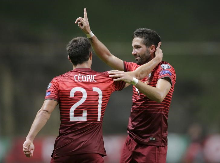 © Reuters. João Moutinho (D), da seleção de Portugal, comemora gol marcado contra a Dinamarca pelas eliminatórias para a Eurocopa, em Braga, ao lado de Cédric Soares