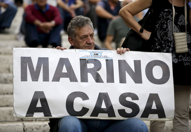 © Reuters. Homem segura cartaz pedindo que Marino, prefeito de Roma, vá para casa 