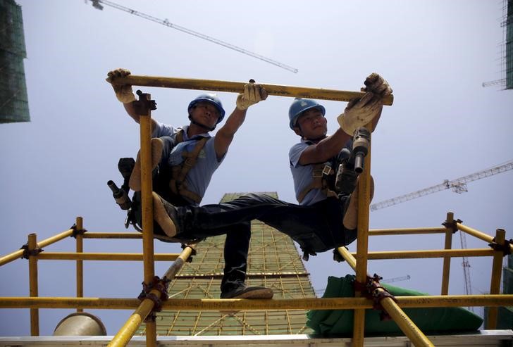 © Reuters. Labourers work on scaffolding at a construction site in Wuhan, Hubei province, China