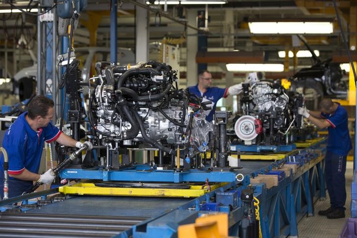 © Reuters. Employees of French carmaker Renault handle a new Clio RS engine on the assembly line at Renault factory in Dieppe