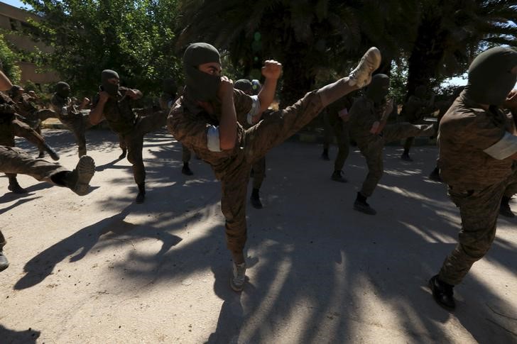 © Reuters. Rebel fighters demonstrate their skills during a military display as part of a graduation ceremony at a camp in eastern al-Ghouta, near Damascus, Syria