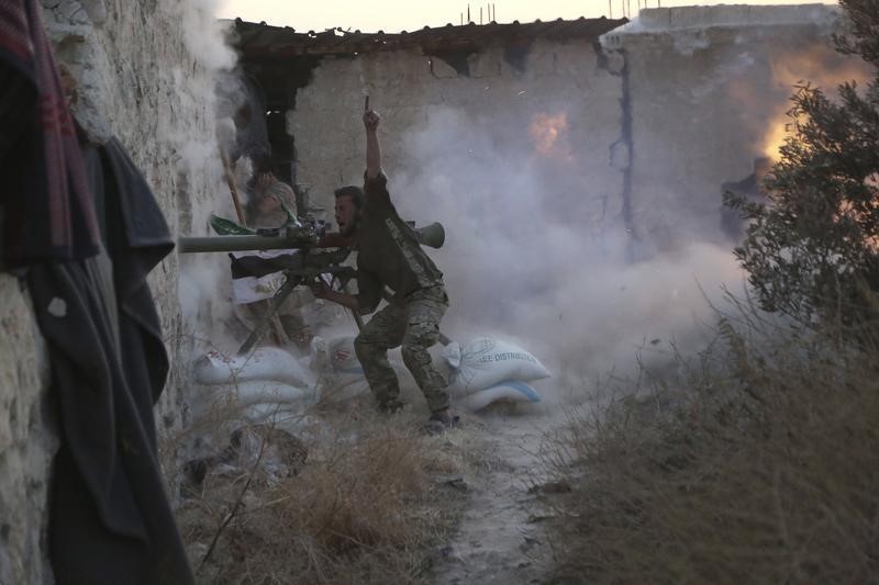 © Reuters. A rebel fighter gestures as he shoots his weapon during clashes with forces loyal to Syria's President Bashar al-Assad on the frontline of Aleppo's Sheikh Saeed neighbourhood