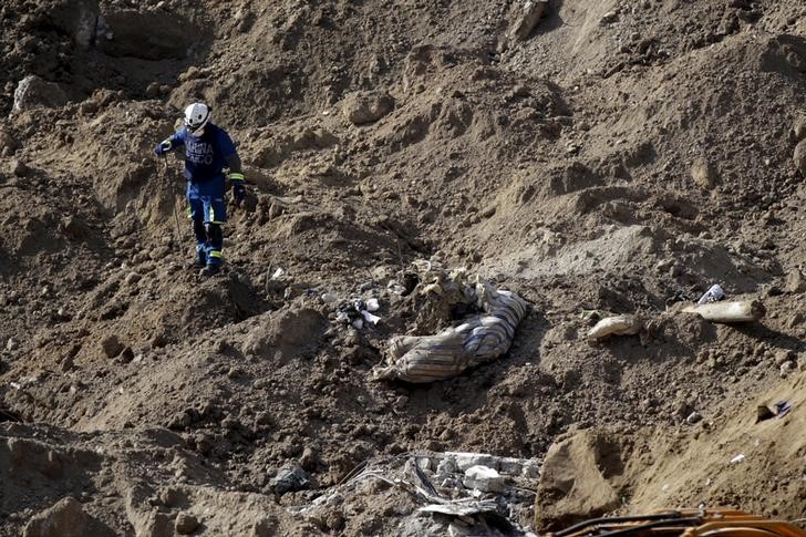 © Reuters. Membro da equipe de resgate busca corpos em Santa Catarina Pinula, na Guatemala