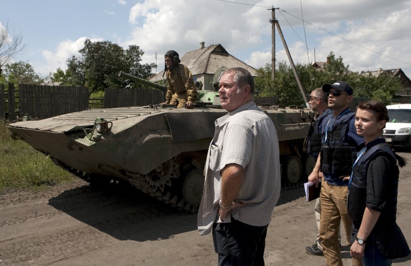 © Reuters. En la imagen de archivo, miembros de la Organización para la Seguridad y la Cooperación en Europa (OSCE) supervisan el retiro de vehículos blindados de fuerzas de la autoproclamada República Popular de Donetsk