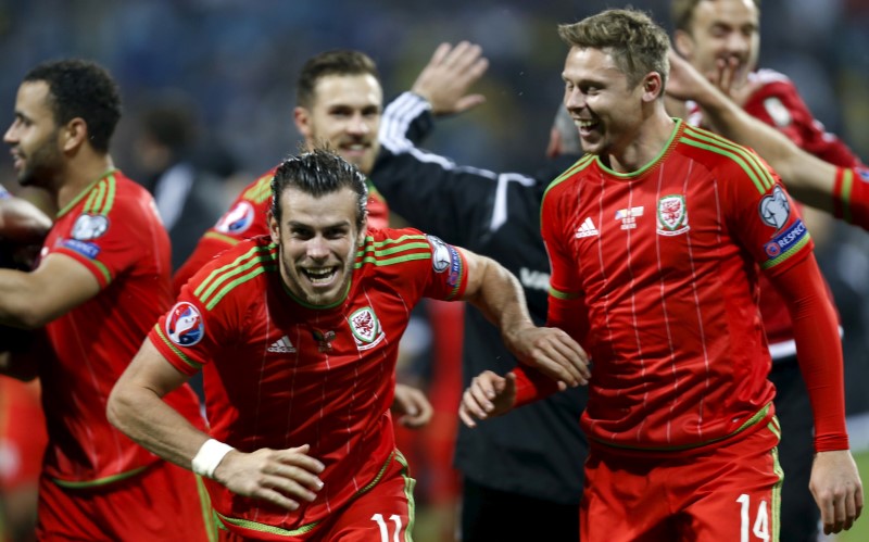 © Reuters. El capitán de la selección de fútbol de Gales, Gareth Bale, y sus compañeros celebran tras clasificar a la Eurocopa 2016 tras un partido con Bosnia