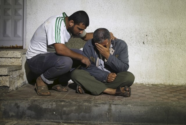 © Reuters. Relatives react outside a hospital morgue after a three-year-old Palestinian girl and her mother were killed after their house was brought down by an Israeli air strike in Gaza