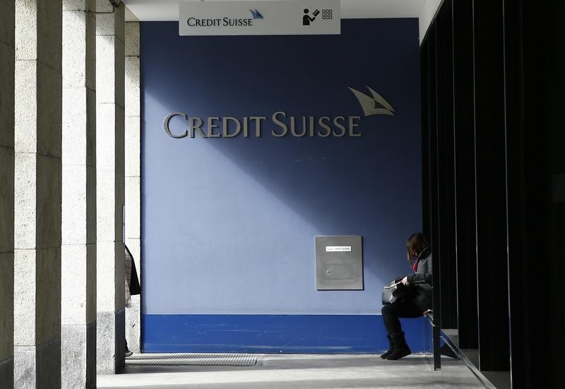 © Reuters. A woman sits outside a branch of the Credit Suisse bank in Bern