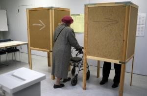 © Reuters. A woman enters a voting booth during regional elections in Vienna