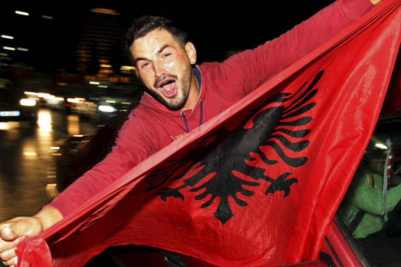 © Reuters. Un fanático albanés festeja después del triunfo de Albania sobre Armenia en un partido clasificatorio para la copa de fútbol Euro 2016