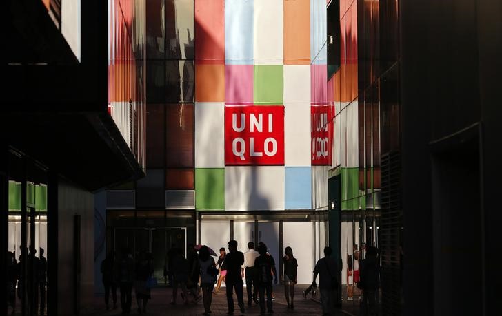 © Reuters. People stand outside a UNIQLO shop in Beijing