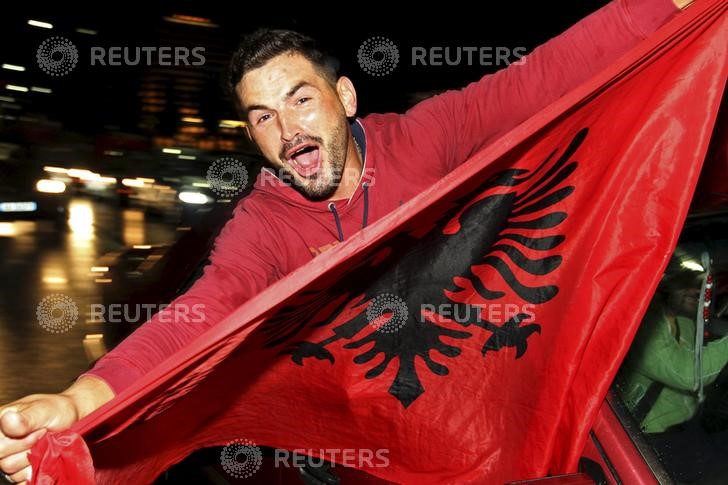 © Reuters. Un fanático albanés festeja después del triunfo de Albania sobre Armenia en un partido clasificatorio para la copa de fútbol Euro 2016