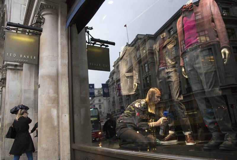 © Reuters. A shop worker adjusts a window display in a  Ted Baker store in London, Britain 