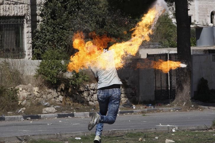 © Reuters. Manifestante palestino atirando coquetel molotov durante confronto em Hebron, na Cisjordânia