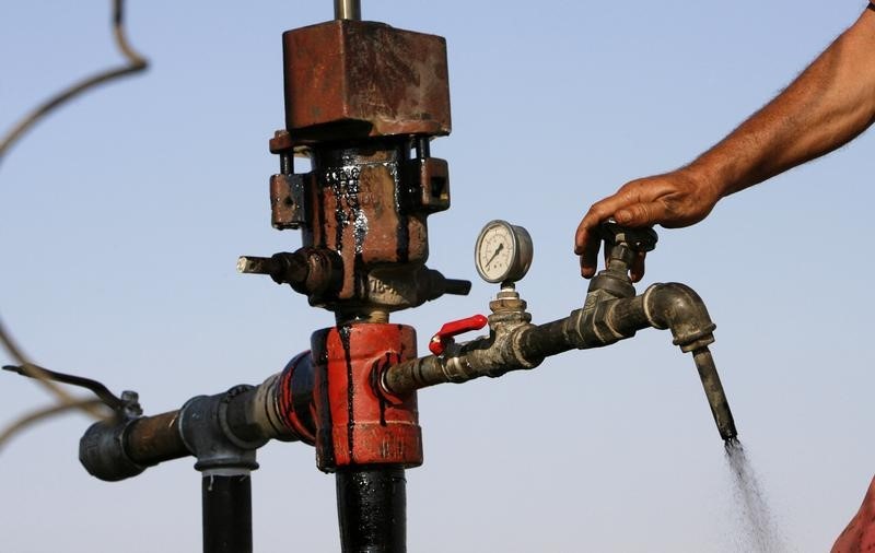 © Reuters. A worker turns a valve to release drilled oil, near the Dead Sea