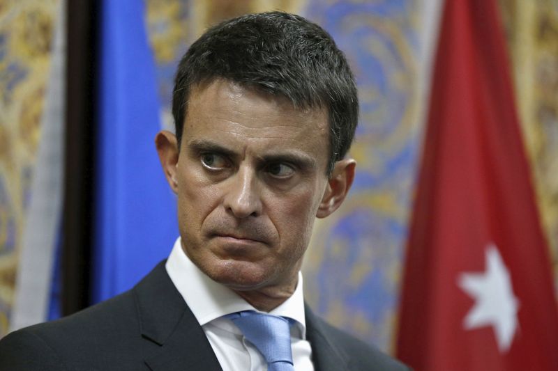 © Reuters. French Prime Minister Manuel Valls listens to the translation during his news conference in Amman