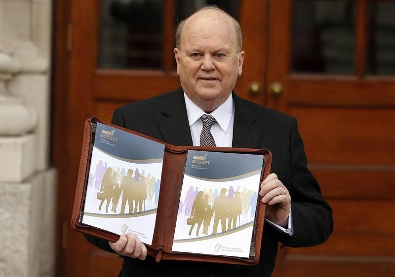 © Reuters. Ireland's Minister for Finance Michael Noonan displays a copy of the Budget on the steps of Government Buildings in Dublin