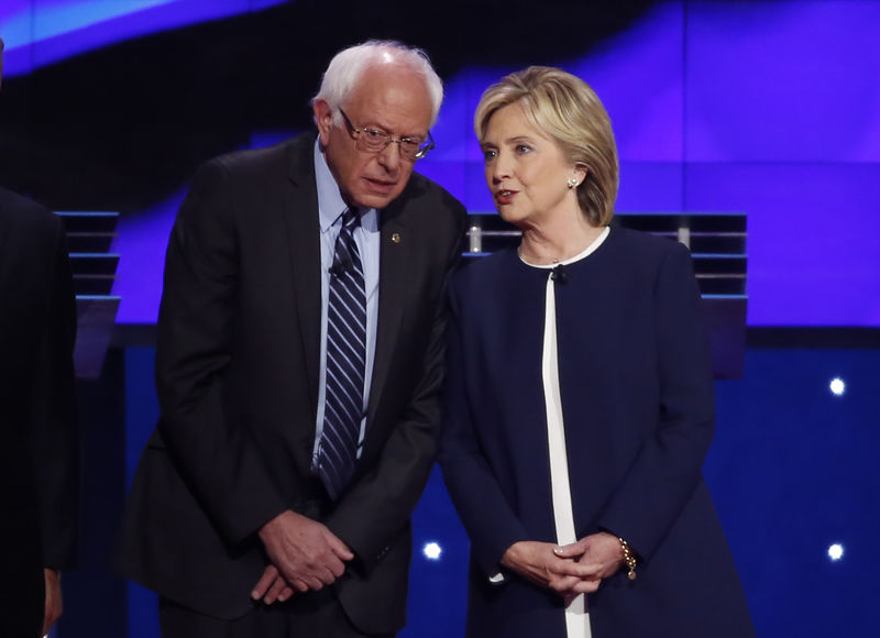 © Reuters. U.S. Democratic presidential candidates Senator Bernie Sanders and former Secretary of State Hillary Clinton talk before the start of the first official Democratic candidates debate of the 2016 presidential campaign in Las Vegas