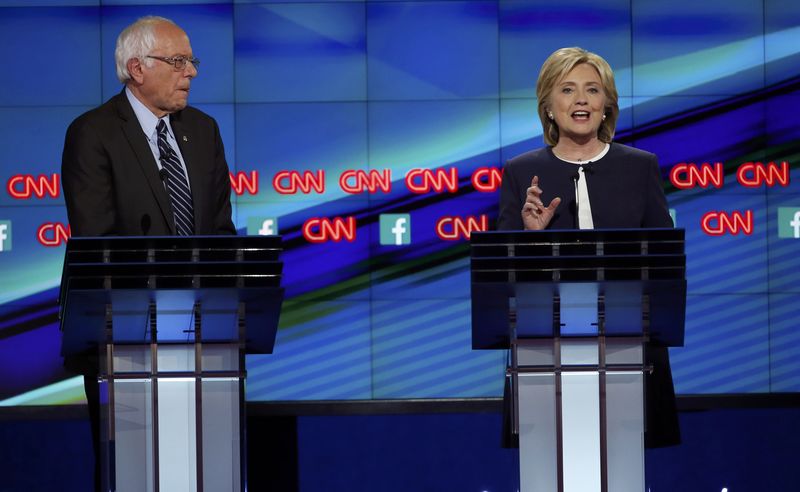 © Reuters. Democratic presidential candidate U.S. Senator Bernie Sanders listens as former Secretary of State Hillary Clinton speaks during the first official Democratic candidates debate of the 2016 presidential campaign in Las Vegas