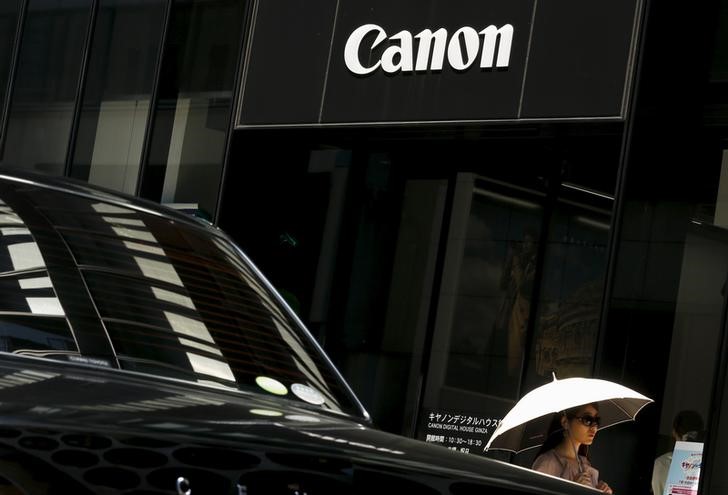 © Reuters. A woman walks past a showroom of Japanese imaging and optical products manufacturer Canon in Tokyo