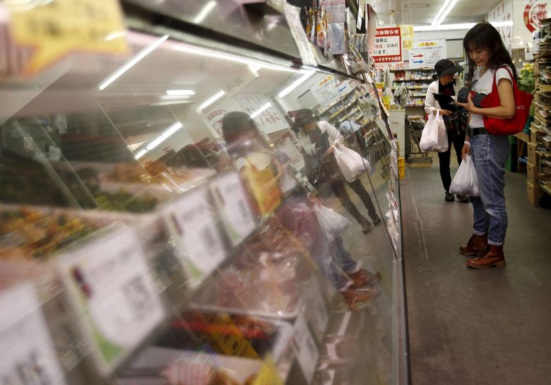 © Reuters. A woman looks at cooked food at a delicatessen at a shopping district in Kamakura