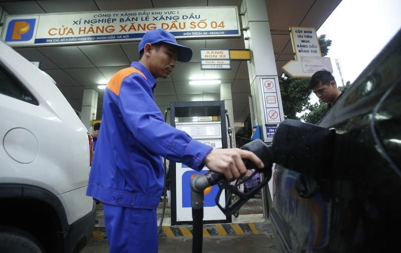 © Reuters. A attendant pumps petrol for a car at a petrol station in Hanoi