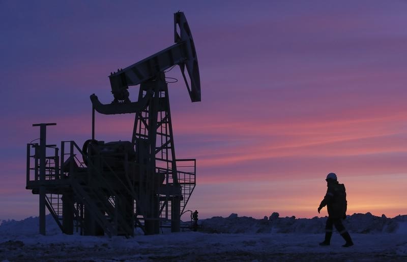 © Reuters. A worker walks past a pump jack on an oil field owned by Bashneft company near Nikolo-Berezovka