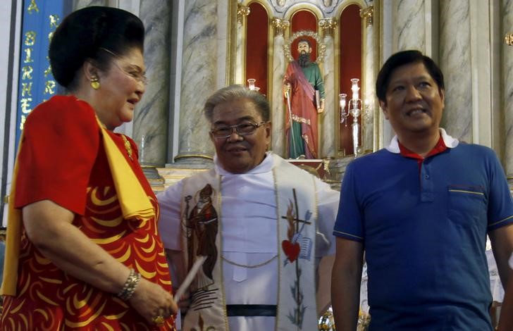 © Reuters. A priest at a church blesses BongBong Marcos in Manila 