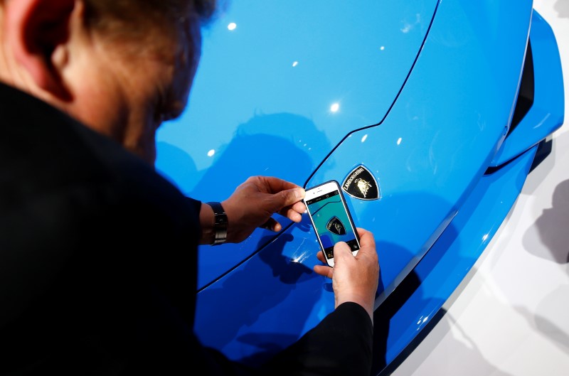 © Reuters. A visitor takes a picture of the logo on the Lamborghini Huracan LP 610-4 Spyder during the Volkswagen group night ahead of the Frankfurt Motor Show (IAA) in Frankfurt