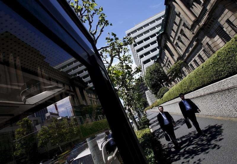 © Reuters. Pedestrians walk on a street in front of the Bank of Japan headquarters in Tokyo