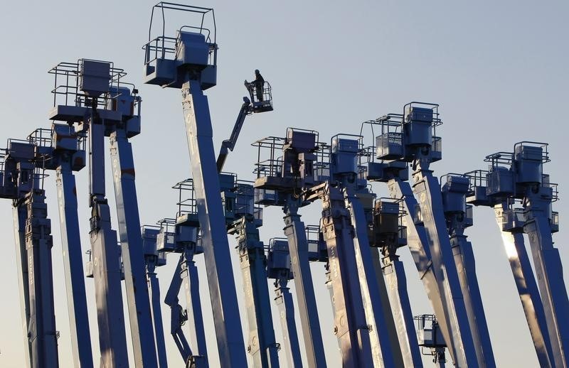 © Reuters. A worker stands on a crane which is parked at a construction site at Keihin industrial zone in Kawasaki