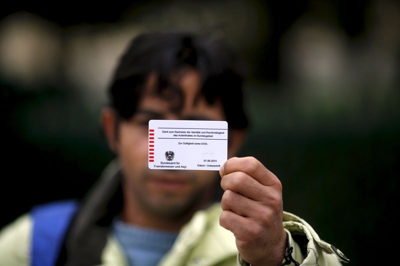 © Reuters. Omar, a cook originally from Deraa,  Syria, shows the back of his Austrian migrant card in Traiskirchen 