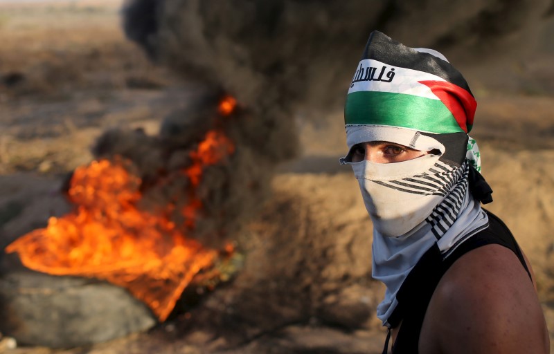 © Reuters. Manifestante palestino durante confronto com tropas israelenses na fronteira entre Israel e a Faixa de Gaza