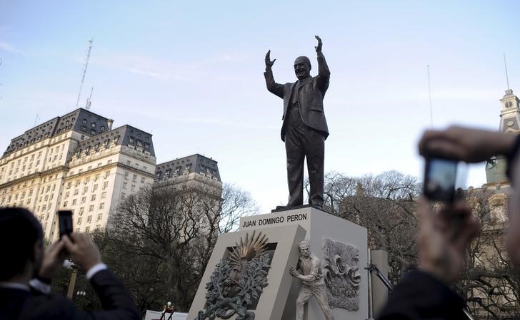 © Reuters. Pedestres tiram foto da recém inaugurada estátua do heroi nacional e ex-presidente argentino Juan Peron
