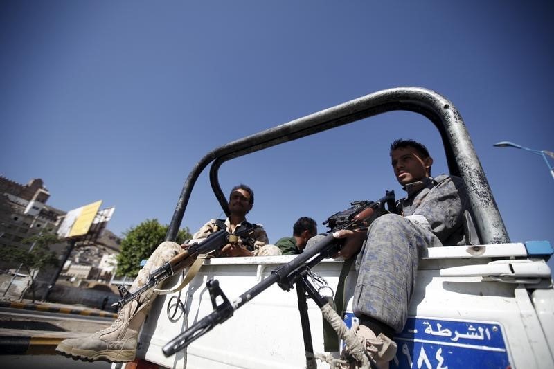 © Reuters. Houthi fighters sit on the back of a police truck patrolling a road where people demonstrated against the Saudi-led air strikes in Yemen's capital Sanaa