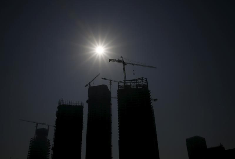 © Reuters. Buildings at a construction site are silhouetted in Beijing, China