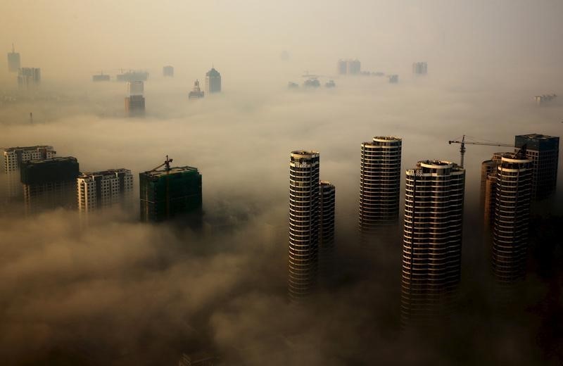 © Reuters. Buildings in construction are seen among mist during a hazy day in Rizhao