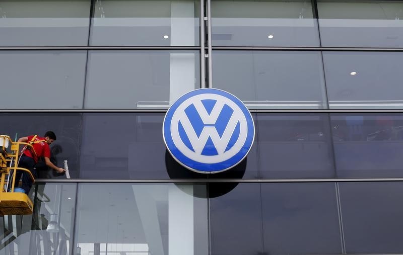 © Reuters. A worker cleans the facade of a Volkswagen dealership near the Andalusian capital of Seville, southern Spain