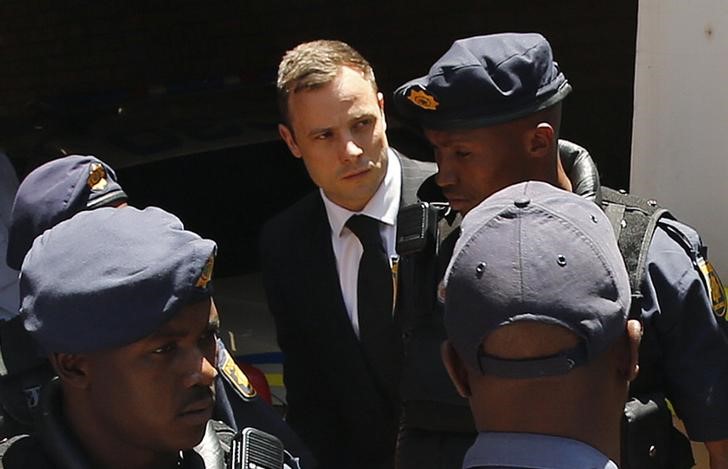 © Reuters. South African Olympic and Paralympic sprinter Pistorius is escorted to a police van after his sentencing at the North Gauteng High Court in Pretoria