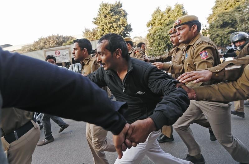 © Reuters. Policemen run along with driver Yadav who is accused of a rape outside a court in New Delhi